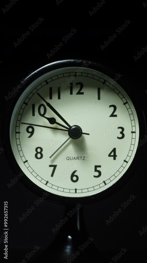 Vertical time lapse video of a clock time passing over a day to night on black background.