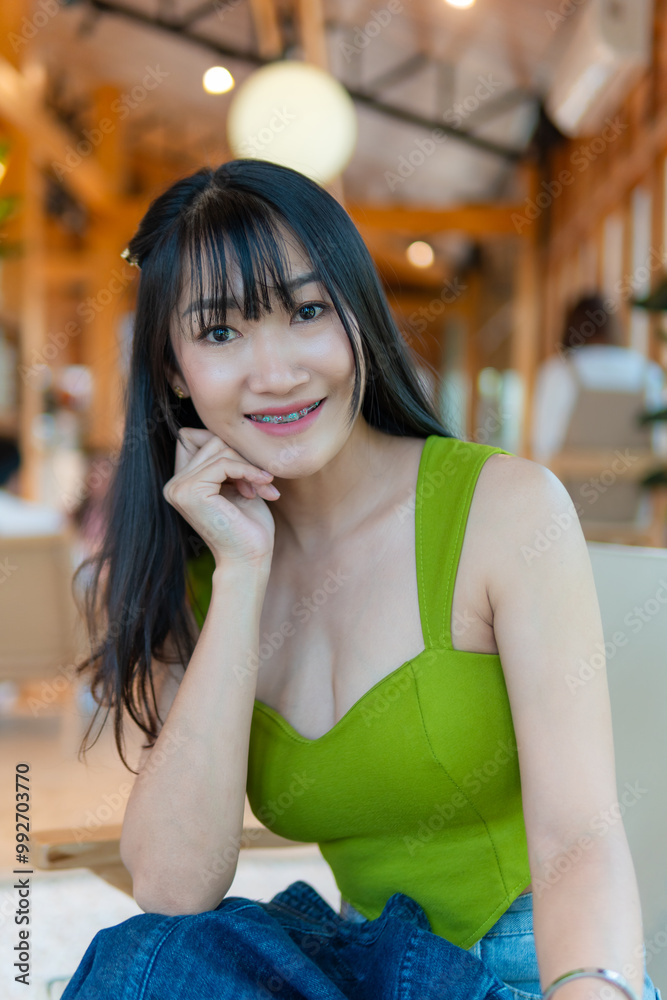 Portrait of beautiful sexy asian woman Wearing a green strapless dress and jean skirt in a cafe Portrait of beautiful sexy asian woman Wearing a green strapless dress and jean skirt in a cafe