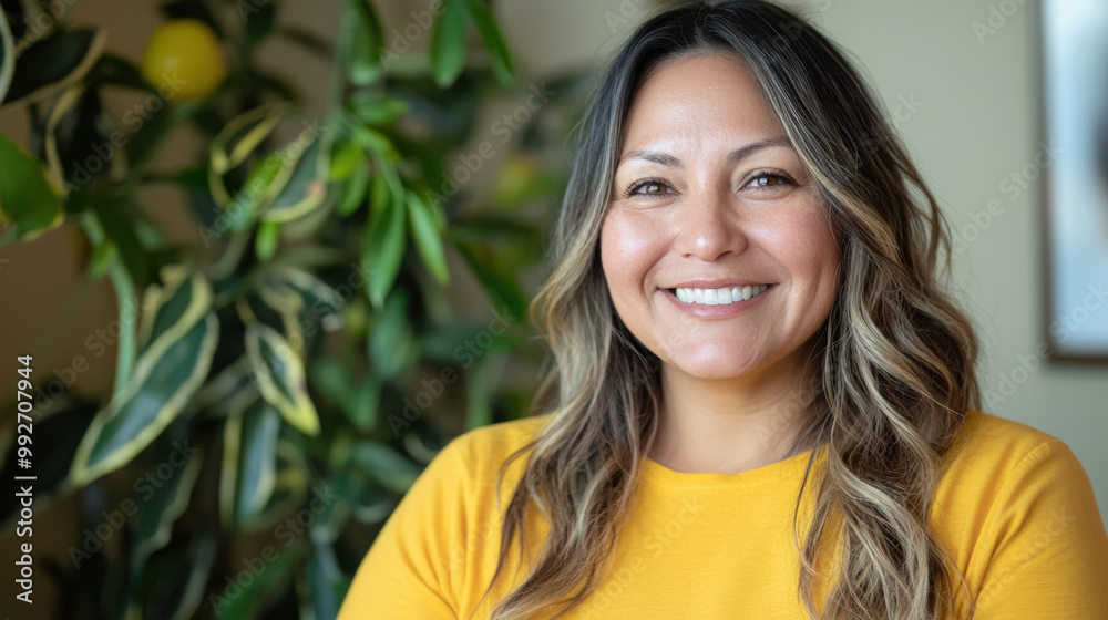 Smiling woman with long hair wearing yellow shirt, surrounded by greenery, exuding warmth and positivity. Her cheerful expression brightens atmosphere Smiling woman with long hair wearing yellow shirt, surrounded by greenery, exuding warmth and positivity. Her cheerful expression brightens atmosphere