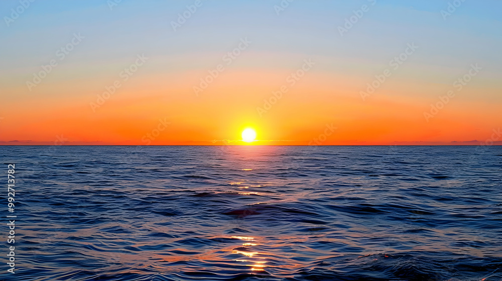 Fototapeta premium A Vivid Sunset Over the Ocean, Casting a Golden Glow on the Rippling Water, Creating a Serene and Majestic Scene
