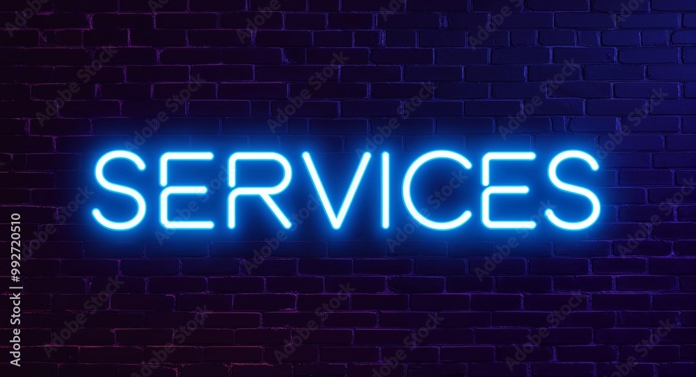 Obraz premium Services word lettering glowing with neon light on dark brick wall background