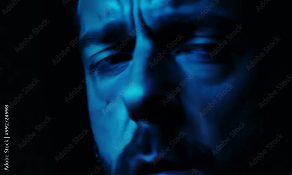 Man Looking Around Concerned in Dark Room with Screens Man Looking Around Concerned in Dark Room with Screens