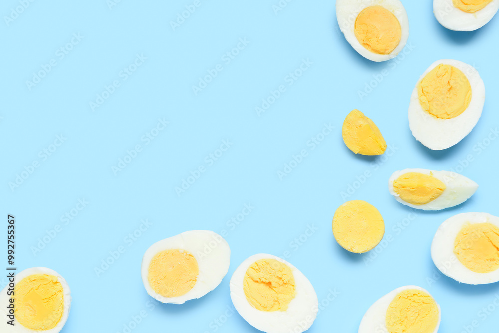 Halves of tasty boiled eggs with slice on blue background Halves of tasty boiled eggs with slice on blue background