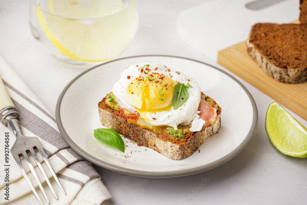 Plate of tasty sandwich with egg on grey background Plate of tasty sandwich with egg on grey background