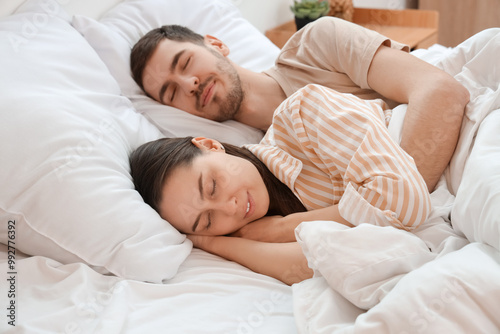 Lovely young couple sleeping in bed