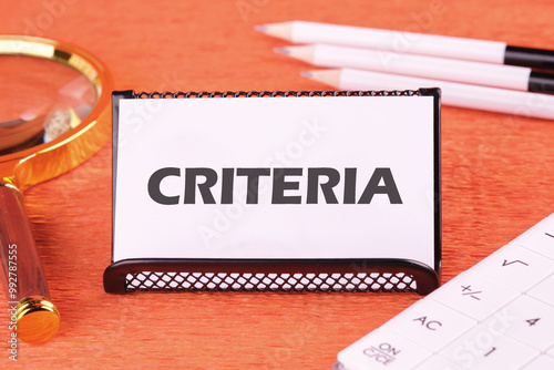 Criteria Controlling Follow Guidelines Conduct Concept. Criteria word on a white business card, close-up in front of an orange background, front view photo