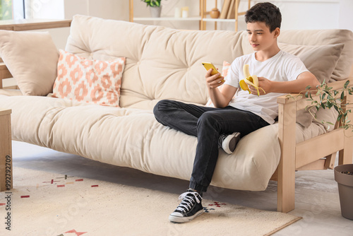 Teenage boy with banana usi...