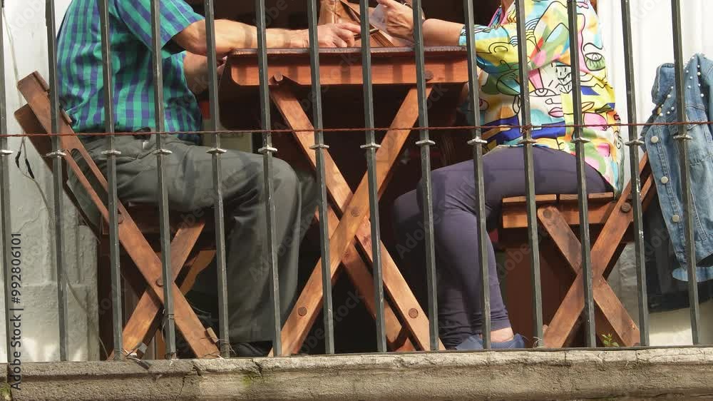 mature couple sitting outside of a balcony looking at the menu of a cafe. Long term relashionship concept, love concept, Stock ビデオ | Adobe Stock