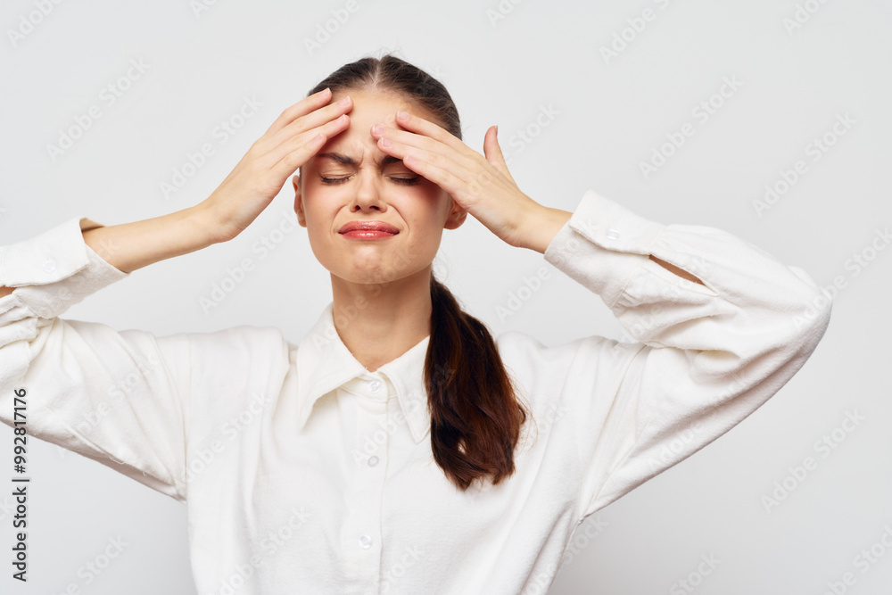 Stress, frustration, headache, young woman, emotional distress, white background, casual clothing, hands on forehead, anxiety, negative emotions Stress, frustration, headache, young woman, emotional distress, white background, casual clothing, hands on forehead, anxiety, negative emotions