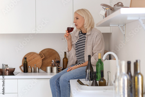 Mature woman drinking wine ...