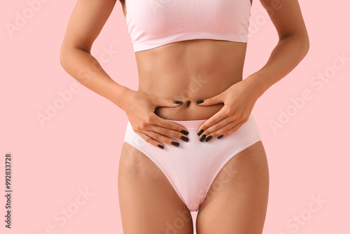 Young woman in underwear with cellulite problem on pink background, closeup