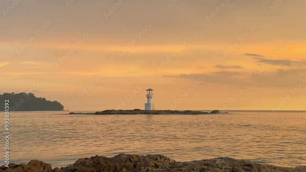 lighthouse amidst calm sea at golden hour time . lighthouse amidst calm sea at golden hour time .