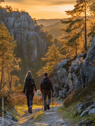 Two hikers walk along a trail through a forest at sunset. AI.