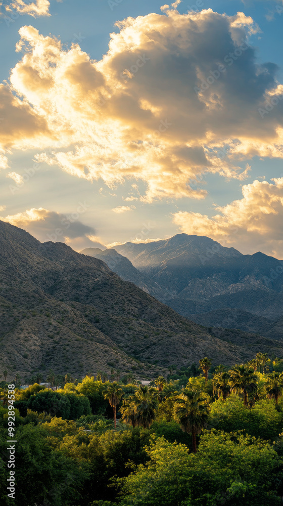 Sunset illuminating mountain landscape with lush greenery in foreground and dramatic clouds over distant peaks Sunset illuminating mountain landscape with lush greenery in foreground and dramatic clouds over distant peaks