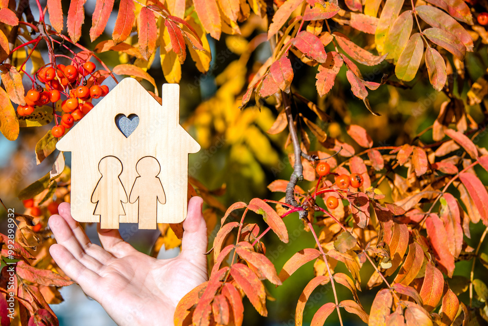Φωτογραφία The symbol of the house in the girl's hand on the background of red rowan trees