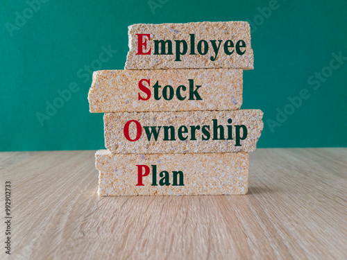 Concept of ESOP - Employee Stock Ownership Plan write on brick blocks. Beautiful green background. Wooden Table. Business concept. photo