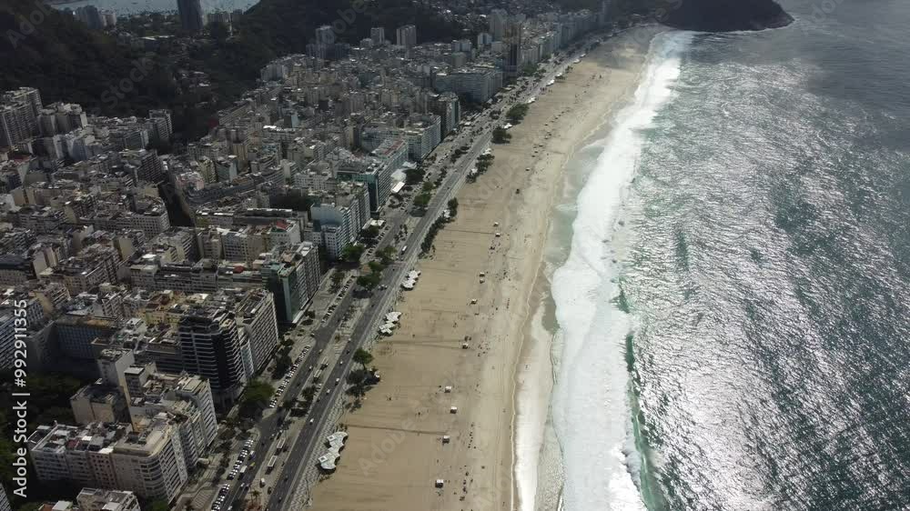 Vista aérea da praia de Copacabana, destacando a orla, o mar azul, a faixa de areia e o movimento na icônica paisagem do Rio de Janeiro, Brasil Vista aérea da praia de Copacabana, destacando a orla, o mar azul, a faixa de areia e o movimento na icônica paisagem do Rio de Janeiro, Brasil