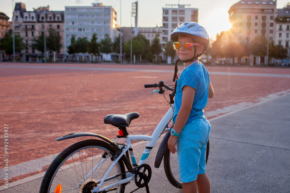 Fototapeta premium A happy youngster rides a bicycle in a vibrant city setting. The scene highlights the energy and well-being gained from cycling, promoting an active lifestyle with an emphasis on safety.