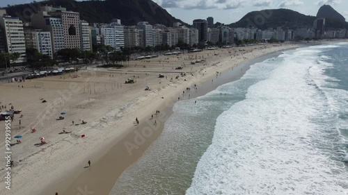 Turistas e banhistas aproveitam o dia na praia de Copacabana, com mar, areia e clima tropical no Rio de Janeiro, Brasil photo