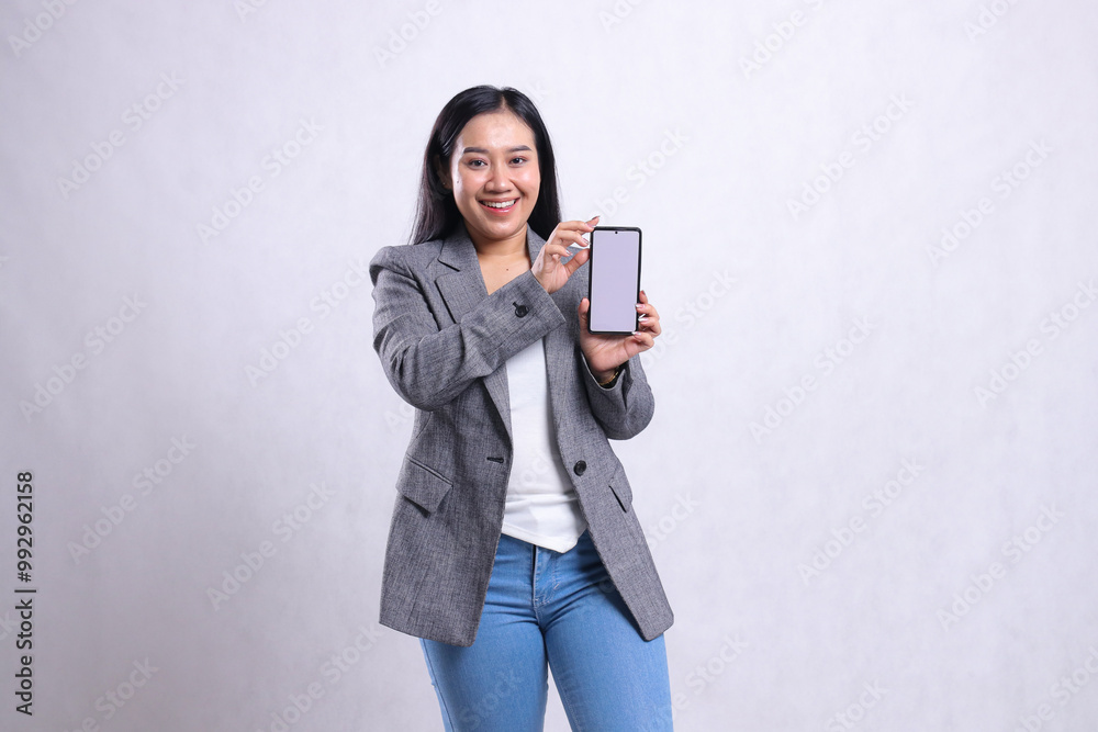 charm young beautiful office girl cheerful to camera both hands holding sideways showing cellphone screen wearing gray suit isolated on white background. for technology, lifestyle, promotion content charm young beautiful office girl cheerful to camera both hands holding sideways showing cellphone screen wearing gray suit isolated on white background. for technology, lifestyle, promotion content