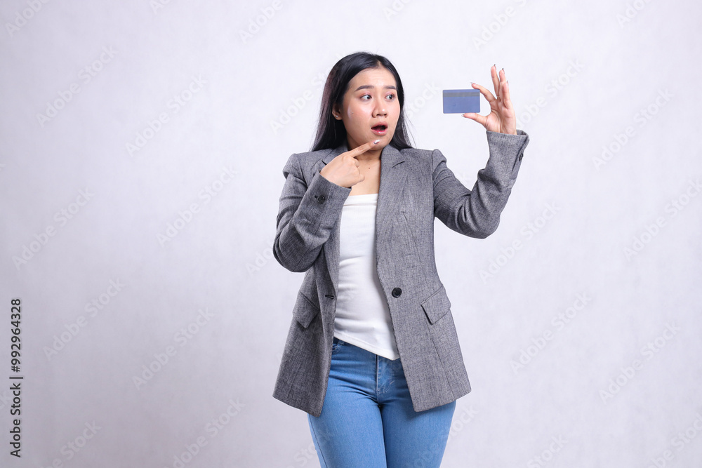 gesture adult office lady shocked pointing, looking and holding debit credit card wearing grey suit standing isolated on white background. for advertising content, lifestyle, finance, transaction gesture adult office lady shocked pointing, looking and holding debit credit card wearing grey suit standing isolated on white background. for advertising content, lifestyle, finance, transaction