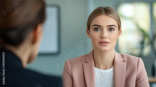 Young professional woman in conversation, focused expression, blurred background. Free Download Young professional woman in conversation, focused expression, blurred background. - GFXLoad