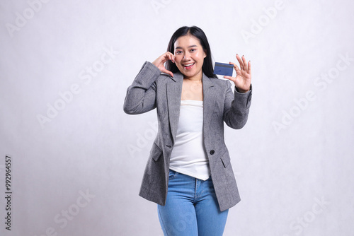 expression of beautiful young office lady asia cheerful hand sign love and hold debit credit card member wearing gray suit standing isolated on white background. for promotional, transaction