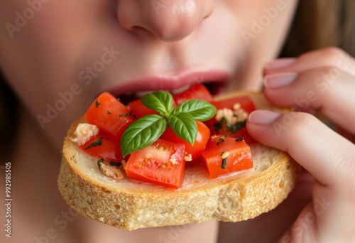 Close up of a person savouring a bite of bruschetta ripe tomatoe photo