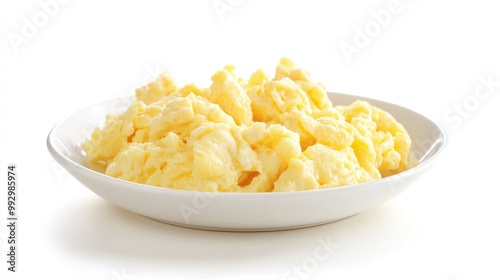 A small plate of scrambled eggs, softly folded and golden, positioned on a white background to create a clean and minimalist food image.