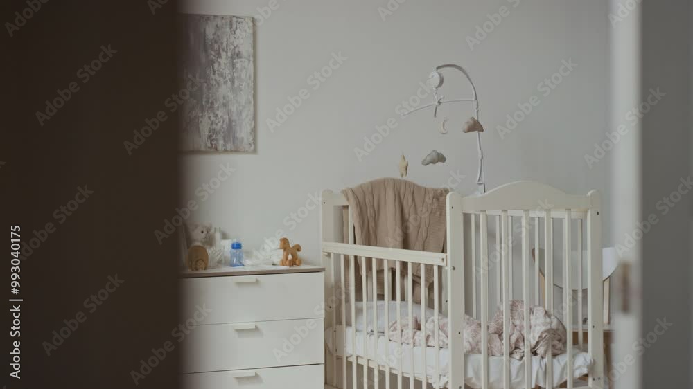 No people shot of baby bedroom interior in pastel colours, white wooden cot and chest of drawers with essential items for care and hygiene of newborn No people shot of baby bedroom interior in pastel colours, white wooden cot and chest of drawers with essential items for care and hygiene of newborn