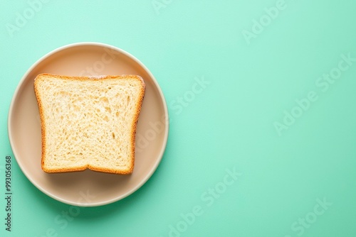 A Single Slice of Toasted Bread on a Beige Plate Against a Mint Green Background