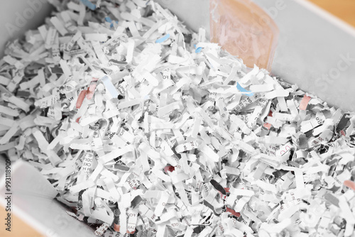 Shredded paper strips in bin, closeup view photo