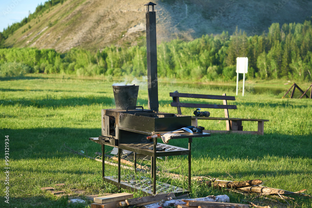 Iron barbecue with a boiling bucket in nature Iron barbecue with a boiling bucket in nature