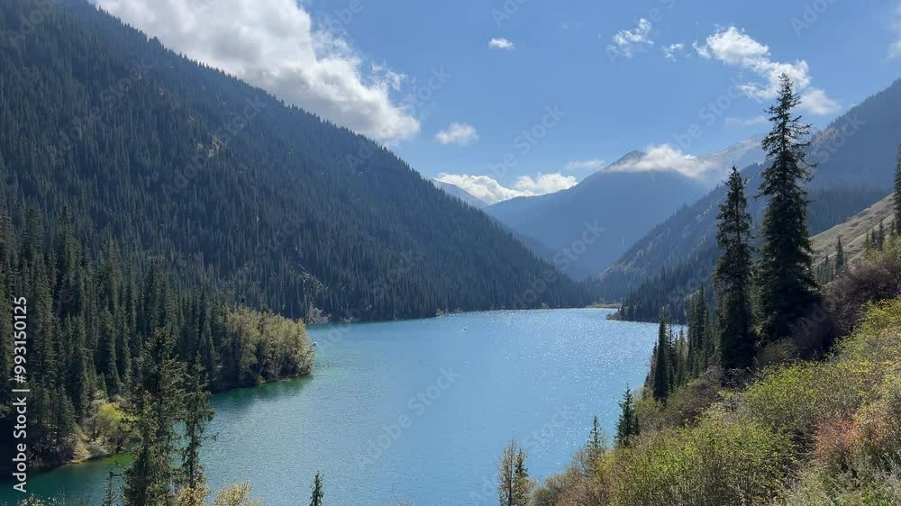 View of Lake Kolsay among mountains covered with coniferous trees View of Lake Kolsay among mountains covered with coniferous trees