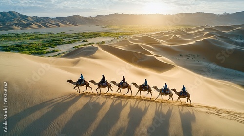   A group riding camels in a desert with mountainous backdrop