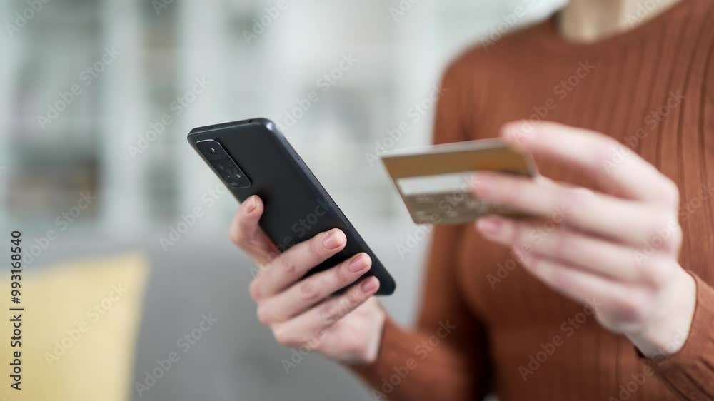 Close up of female hands holding credit card and phone. Young lady doing online shopping typing data on smartphone while sitting at home. Woman makes a purchase, e-commerce, technology, convenience Close up of female hands holding credit card and phone. Young lady doing online shopping typing data on smartphone while sitting at home. Woman makes a purchase, e-commerce, technology, convenience