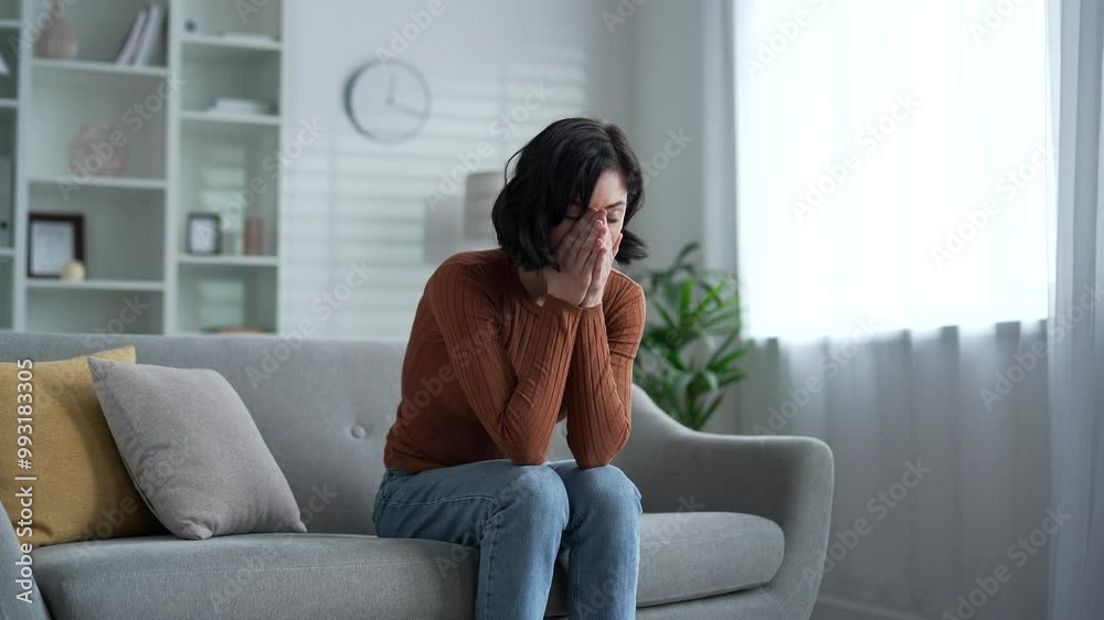 Thoughtful female has depression, suffering from mental pain sitting on sofa in living room at home. Sad lonely young adult woman has personal problems, stress, worries, feels despair, disappointment Thoughtful female has depression, suffering from mental pain sitting on sofa in living room at home. Sad lonely young adult woman has personal problems, stress, worries, feels despair, disappointment