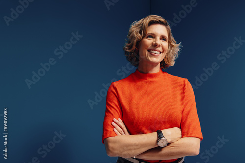 Confident mature businesswoman in vibrant colorblocking portrait with a blue and orange monochromatic set photo