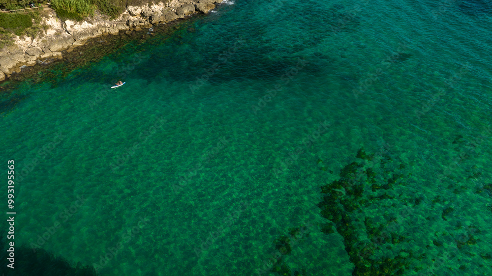 Aerial view of a couple surfing on a sup in the Mediterranean Sea. Aerial view of a couple surfing on a sup in the Mediterranean Sea.