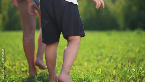 A group of children are running barefoot on the grass. Foot walk nature concept. barefooted walking on grass. A group of children are barefooted walking on the grass lifestyle. photo