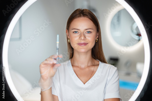 Beautiful happy woman doctor cosmetologist holding filler injection in health and beauty clinic