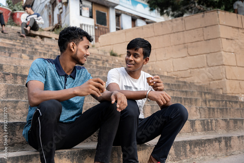 Photography Indian friends sipping traditional chai tea sitting on steps