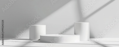 White cylindrical podiums set against a plain background, minimalist, soft shadows, professional product mockup design