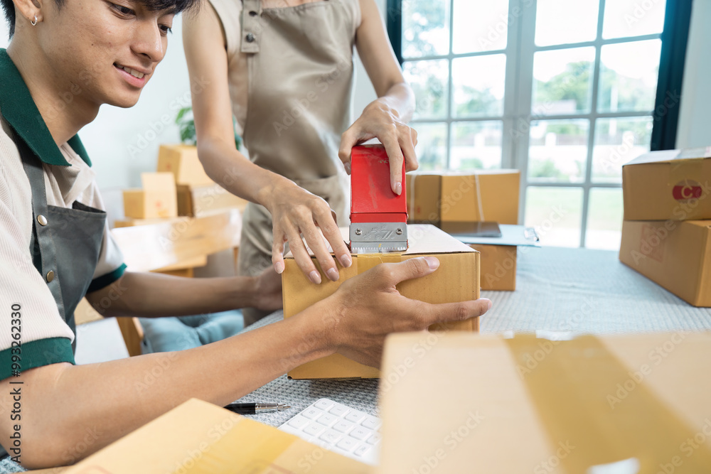 Young Entrepreneur Packing Boxes for Shipping in a Modern Home Office Setting Young Entrepreneur Packing Boxes for Shipping in a Modern Home Office Setting