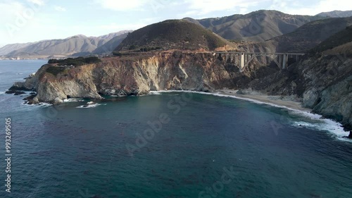Aerial of the rugged coastline of Big Sur California. The Pacific Coast Highway and the famous Bixby Creek Bridge can be seen.