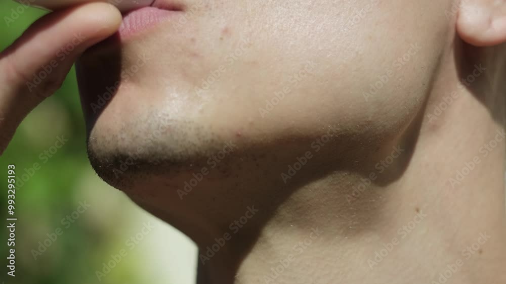 Close-up of a young man drinking tea from a small white cup. Close-up of a young man drinking tea from a small white cup.