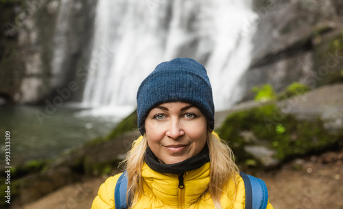 Young woman portrait after a trekking next to river waterfall - Travel, nature and winter sport concept - Focus on face