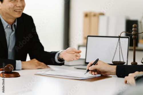 Legal Consultation: Signing Documents. A lawyer and client review contract details, signifying trust and legal expertise.