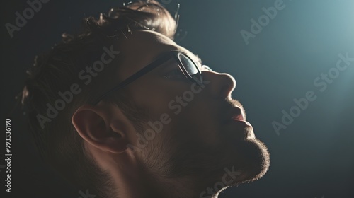 Pensive Profile of a Man in Glasses with Dramatic Lighting - Introspective and Contemplative Mood, Lifestyle Photograph photo