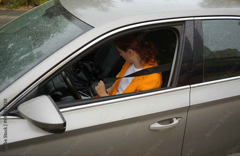 Naklejka premium Portrait of a girl driving a car in the city. traveling by automobile and enjoying road trip